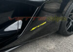 Black Z06 Corvette with accelerate yellow Z06 emblem overlay